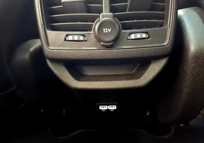 Vue rapprochée de la console arrière noire du Peugeot 3008 avec prise 12V et ports USB visibles.