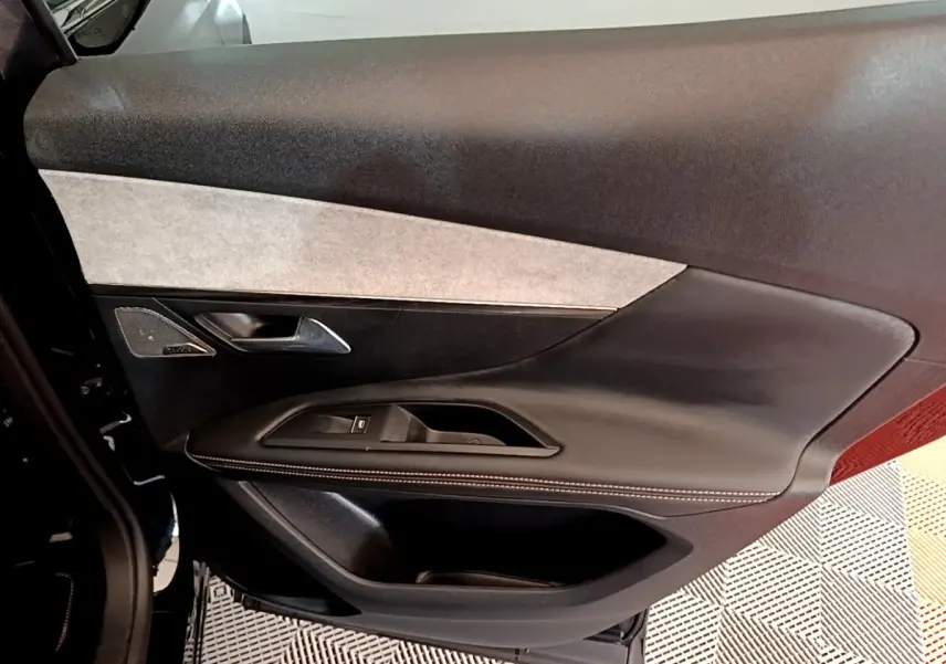 Vue rapprochée de la porte avant gauche noire du Peugeot 3008 2022 avec garniture cuir et insert tissu clair.