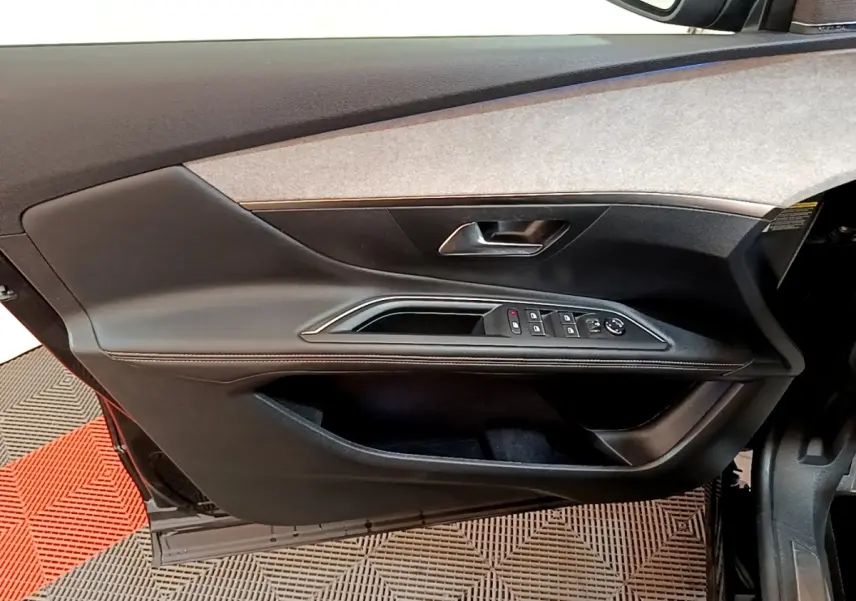 Vue intérieure du panneau de porte avant gauche noir du Peugeot 3008 GT Pack 2022 avec commandes électriques et poignée argentée.