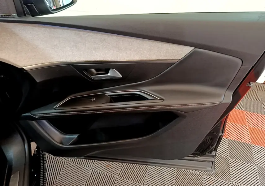 Vue intérieure côté gauche de la porte avant noire du Peugeot 3008 GT Pack 2022 avec garniture tissu et cuir.