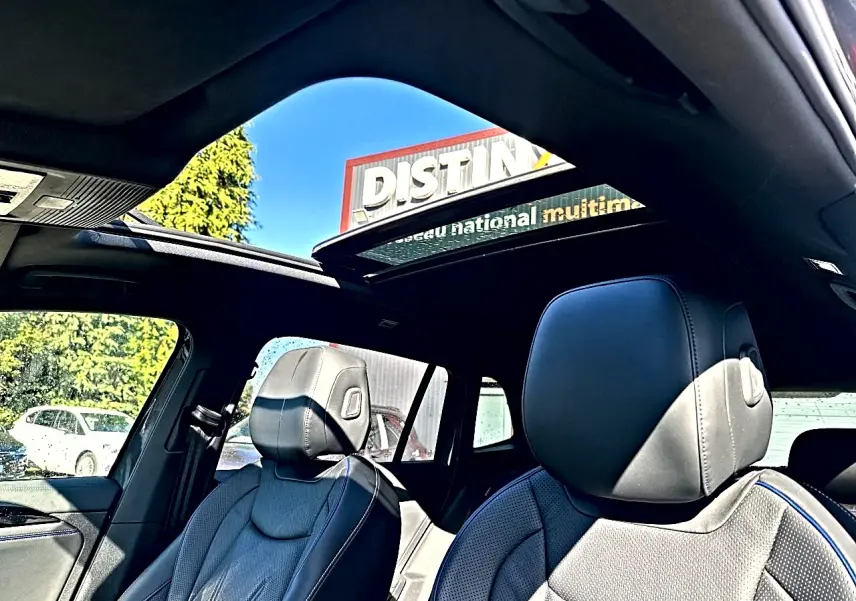 Vue intérieure du Volkswagen Tiguan 2024 gris dauphin, sièges cuir noir R-Line et toit ouvrant panoramique ouvert.
