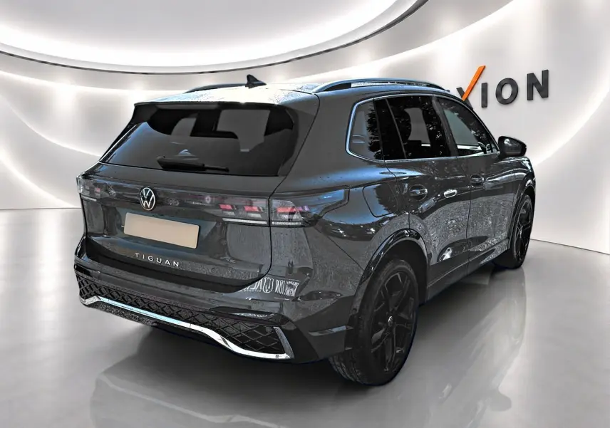 Volkswagen Tiguan 2024 gris dauphin en 3/4 arrière droit, avec jantes noires et toit ouvrant panoramique.