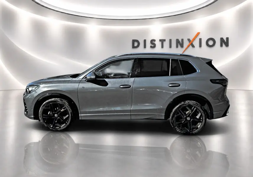 Volkswagen Tiguan 2024 gris dauphin en profil gauche, jantes noires et toit panoramique visible.