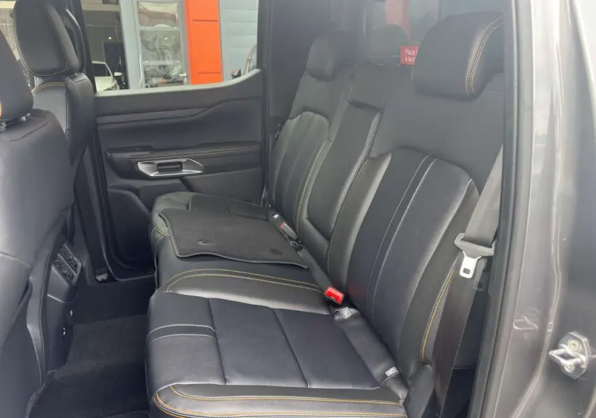 Vue côté droit de l'intérieur arrière du Ford Ranger Wildtrak 2026, sièges cuir noirs avec surpiqûres jaunes.
