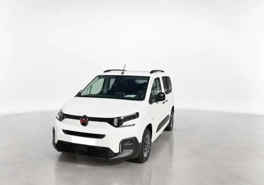 Vue 3/4 avant droite du Citroën Berlingo Kaolin white avec barres de toit et protections latérales noires.