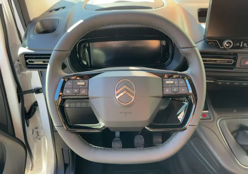 Vue rapprochée du volant cuir multifonctions du Citroën Berlingo Kaolin White avec tableau de bord et écran tactile.