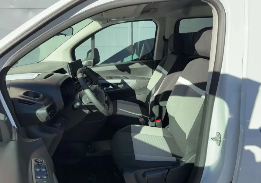 Vue intérieure côté conducteur du Citroën Berlingo Kaolin white 2026, sièges tissu bicolore et tableau de bord moderne.