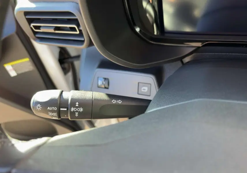 Gros plan sur la commande des feux et clignotants à gauche du volant dans l’habitacle du Citroën Berlingo Kaolin White.