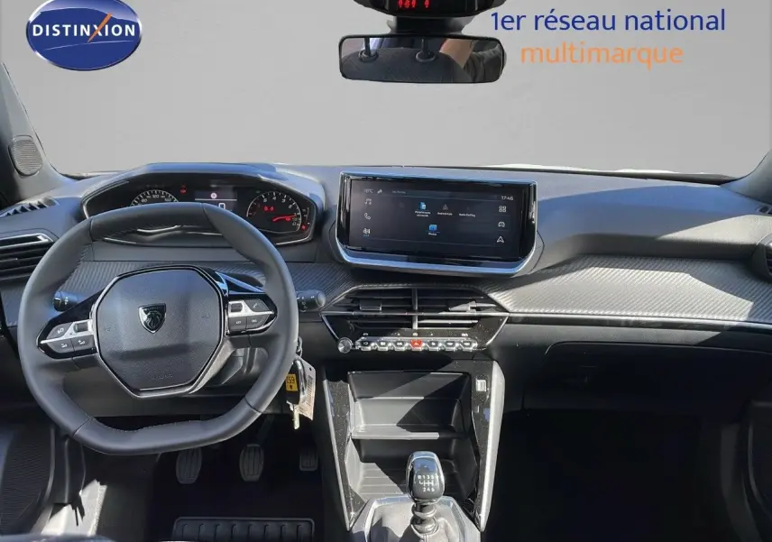 Vue intérieure frontale du Peugeot 2008 blanc Okenite, mettant en valeur le volant compact et l'écran tactile central.