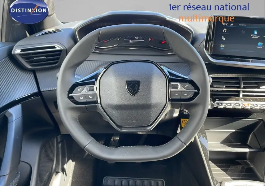 Vue rapprochée du volant noir du Peugeot 2008 2025 avec tableau de bord et écran tactile moderne.
