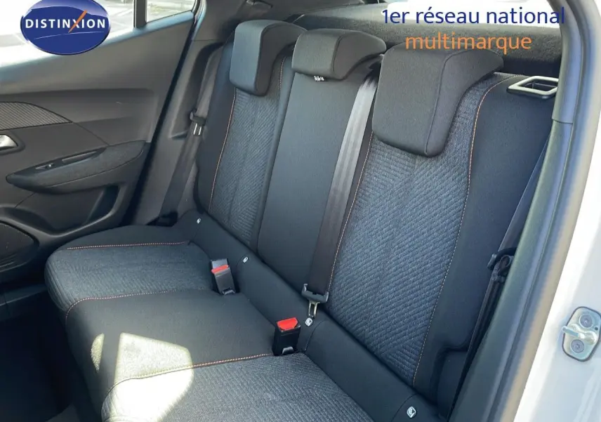 Vue intérieure arrière droite des sièges noirs avec surpiqûres orange du Peugeot 2008 blanc Okenite 2025.