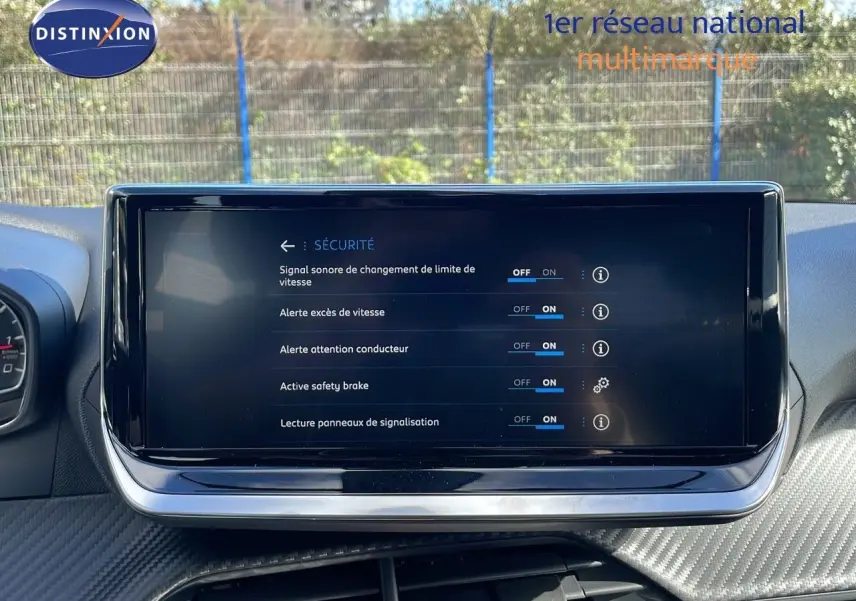 Écran tactile central affichant les réglages de sécurité du Peugeot 2008 blanc, vue intérieure frontale.