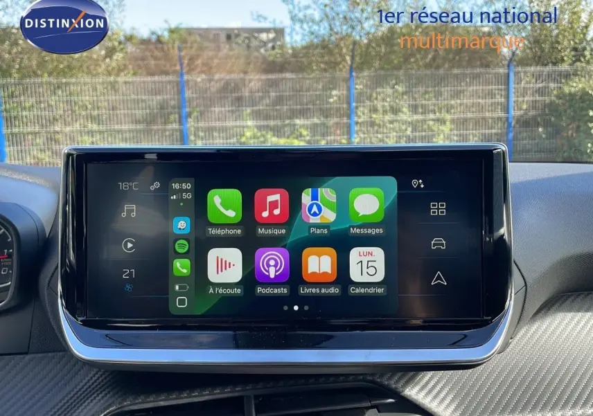 Écran tactile central affichant Apple CarPlay dans l'habitacle d'une Peugeot 2008 blanche vue de face.