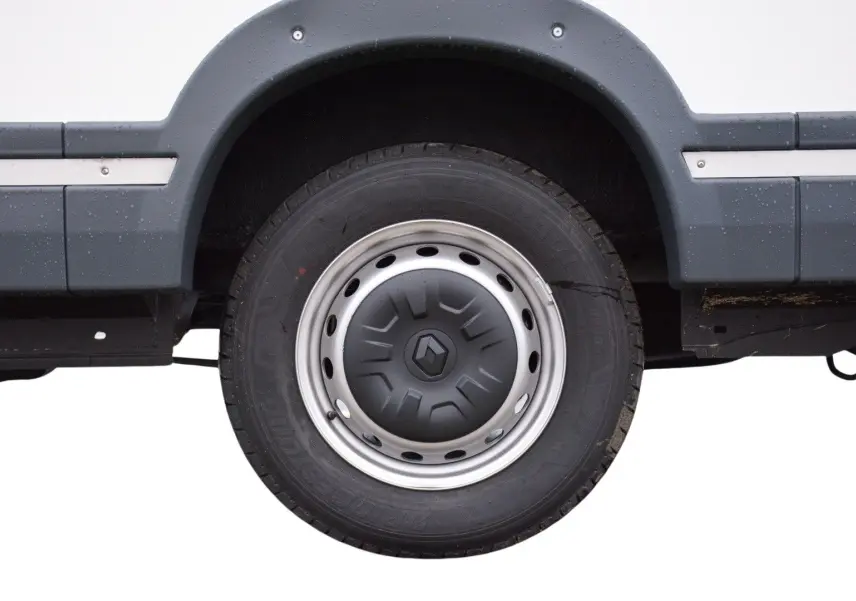 Gros plan sur la roue arrière droite blanche d’un Renault Master Plancher Cabine 2024 avec jante acier et enjoliveur gris.