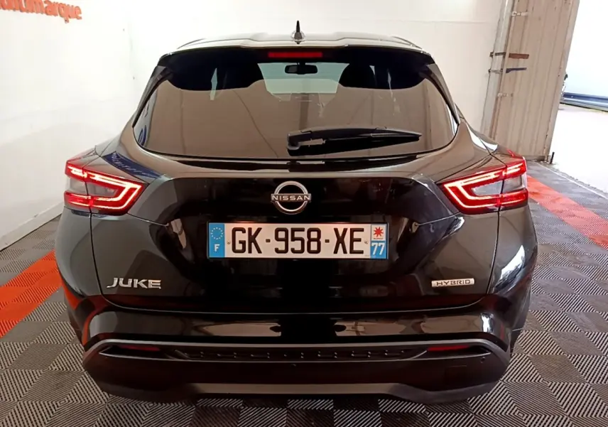 Vue arrière d'un Nissan Juke Hybrid noir 2022 avec feux LED allumés et badges Juke et Hybrid visibles.