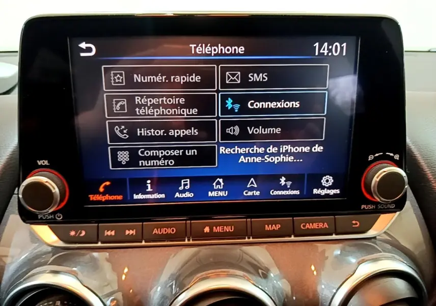 Écran tactile central du Nissan Juke Hybrid 2022 affichant le menu téléphone avec commandes autour, intérieur noir.