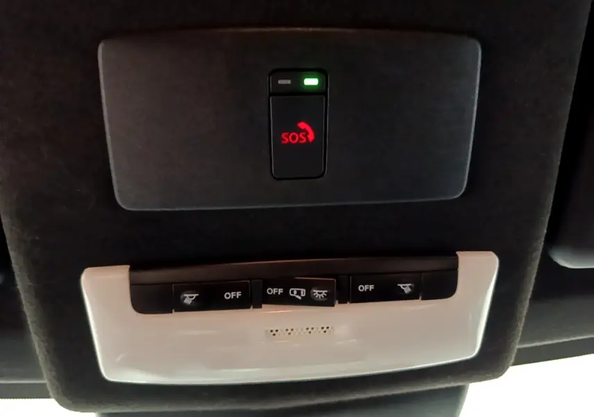 Vue en gros plan du plafonnier noir avec bouton SOS rouge et commandes d'éclairage du Nissan Juke Hybrid 2022.