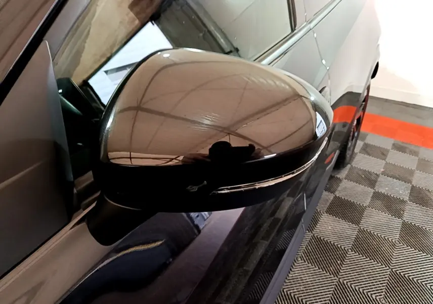 Rétroviseur côté gauche noir brillant du Nissan Juke Hybrid 143 Business+ 2022, vue rapprochée en angle oblique.