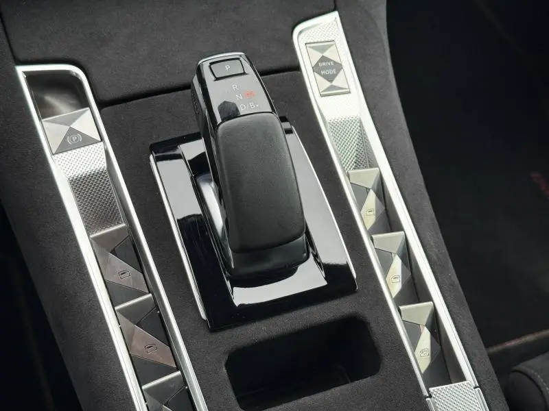 Gros plan sur la console centrale du DS7 E-TENSE 2024, avec levier de vitesses automatique et boutons en finition argentée.