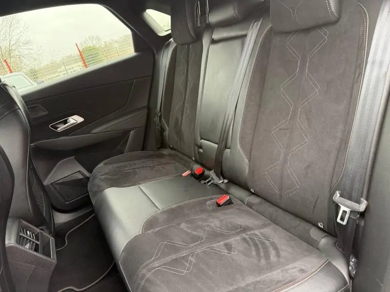Vue intérieure du siège arrière en cuir et alcantara noir du DS7 E-TENSE 2024, avec surpiqûres décoratives visibles.