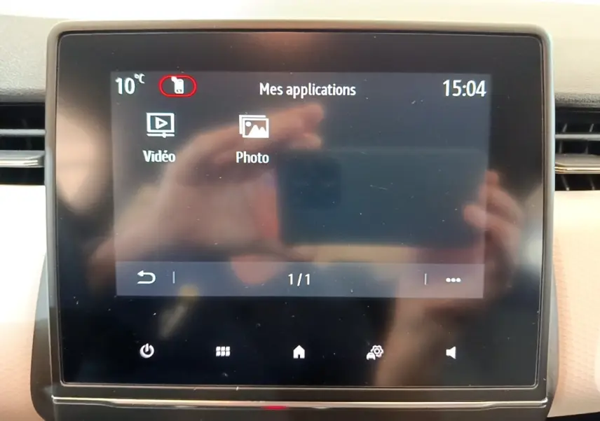 Écran tactile central de la Renault Clio Evolution SCe 65 affichant les applications vidéo et photo, avec interface en français.
