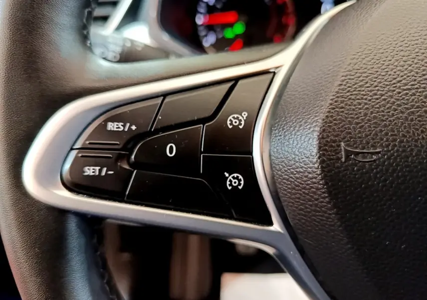 Gros plan sur le volant cuir synthétique de la Renault Clio bleu 2022, avec commandes du régulateur de vitesse.