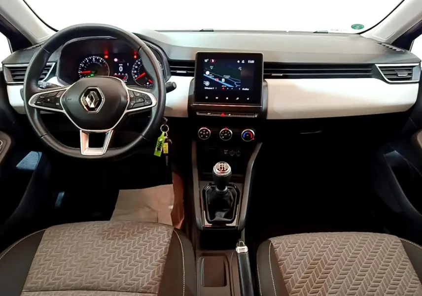 Vue intérieure avant de la Renault Clio bleu, montrant le volant multifonctions en cuir et l’écran tactile central.