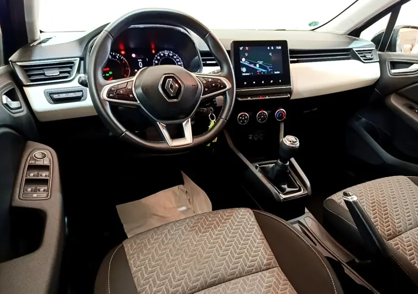 Vue intérieure avant de la Renault Clio Evolution 2022, volant cuir multifonctions et écran tactile de navigation visible.