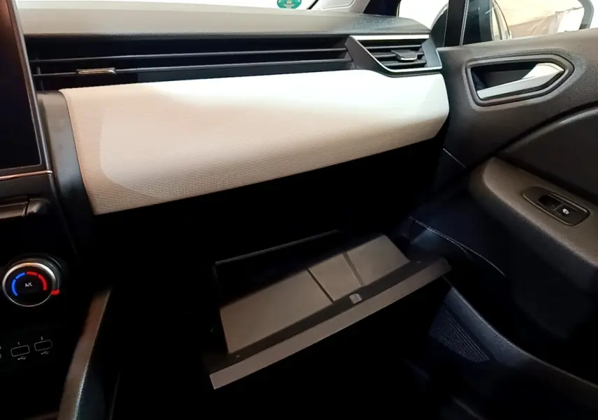 Intérieur de la Renault Clio Evolution SCe 65 2022, vue côté passager avec boîte à gants ouverte et tableau de bord bicolore.