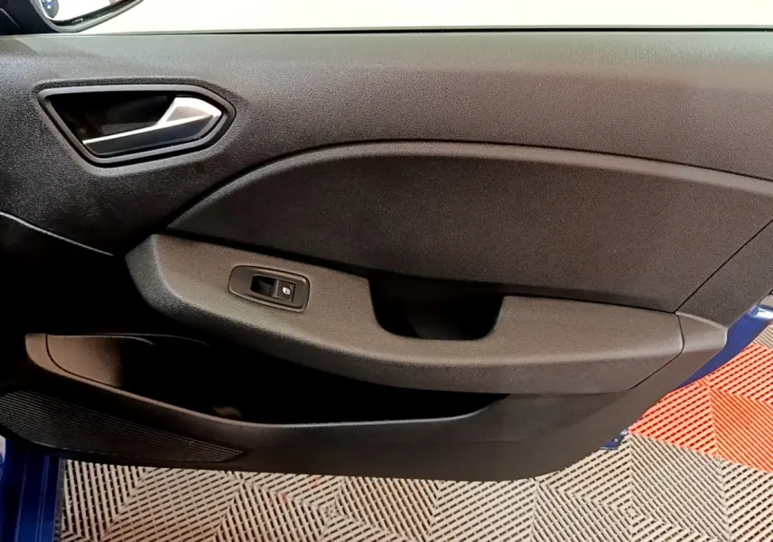 Vue intérieure du panneau de porte côté conducteur d’une Renault Clio bleu 2022, avec commande de vitre électrique.