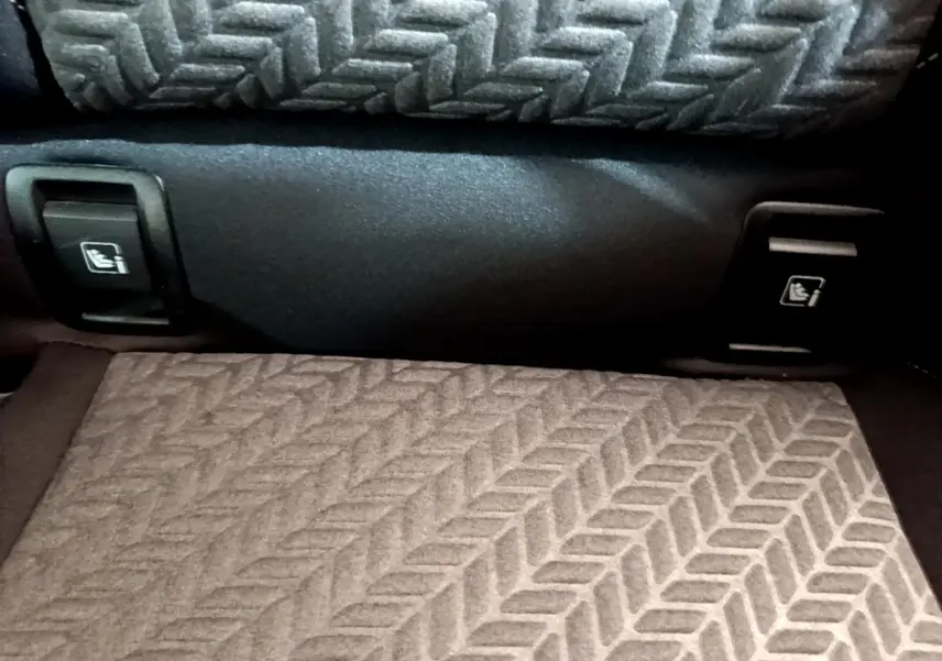 Détail des commandes de rabattement des sièges arrière dans le coffre de la Renault Clio Evolution bleu.