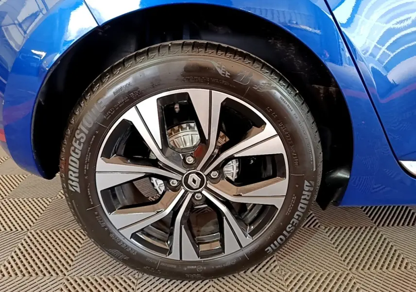 Gros plan sur la roue avant droite de la Renault Clio bleu 2022 avec jante alliage et logo Renault au centre.