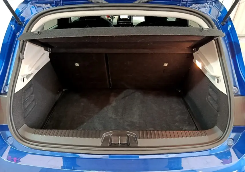Coffre ouvert vu de l'arrière d'une Renault Clio Evolution bleu 2022, avec tablette cache-bagages relevée.