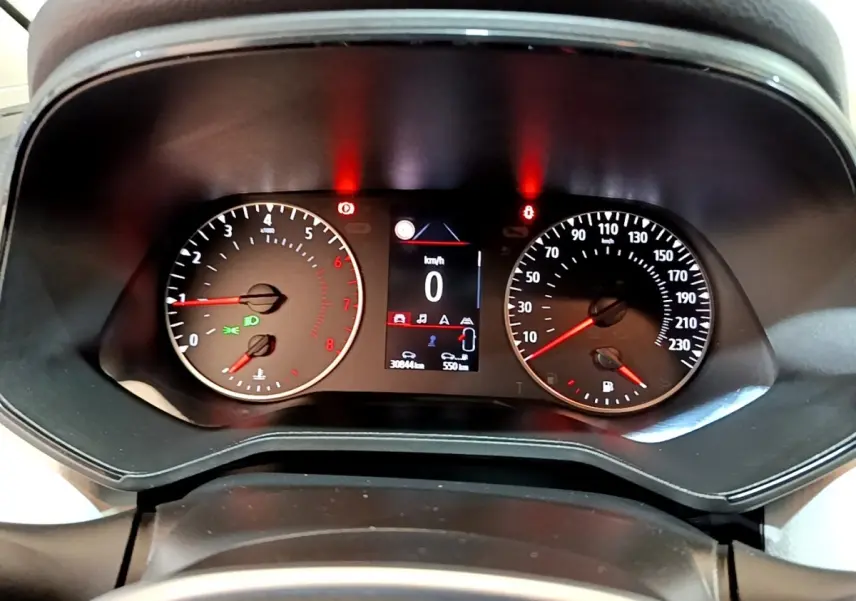 Vue rapprochée du tableau de bord de la Renault Clio bleu 2022, affichage digital et compte-tours analogiques.