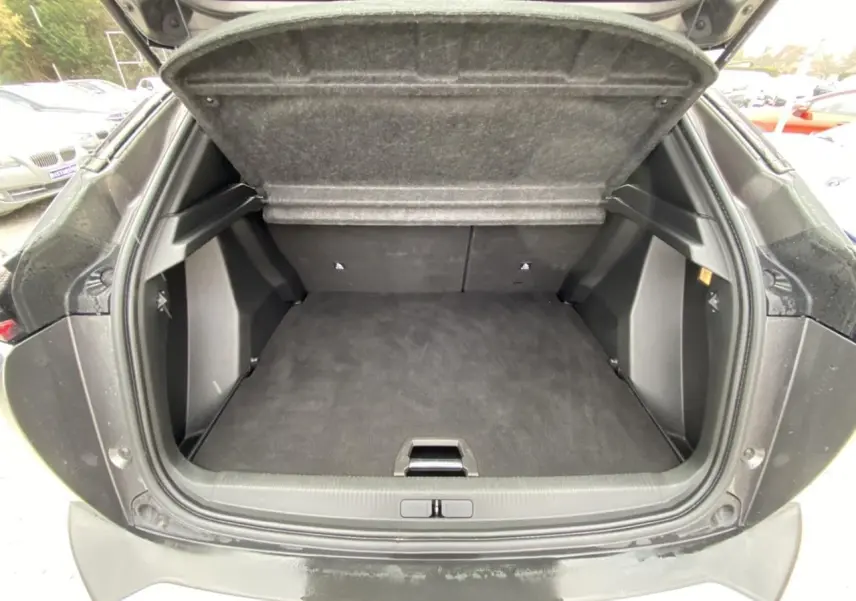 Coffre ouvert vu de l'arrière d'un Peugeot 2008 gris foncé, montrant un espace de chargement propre et spacieux.