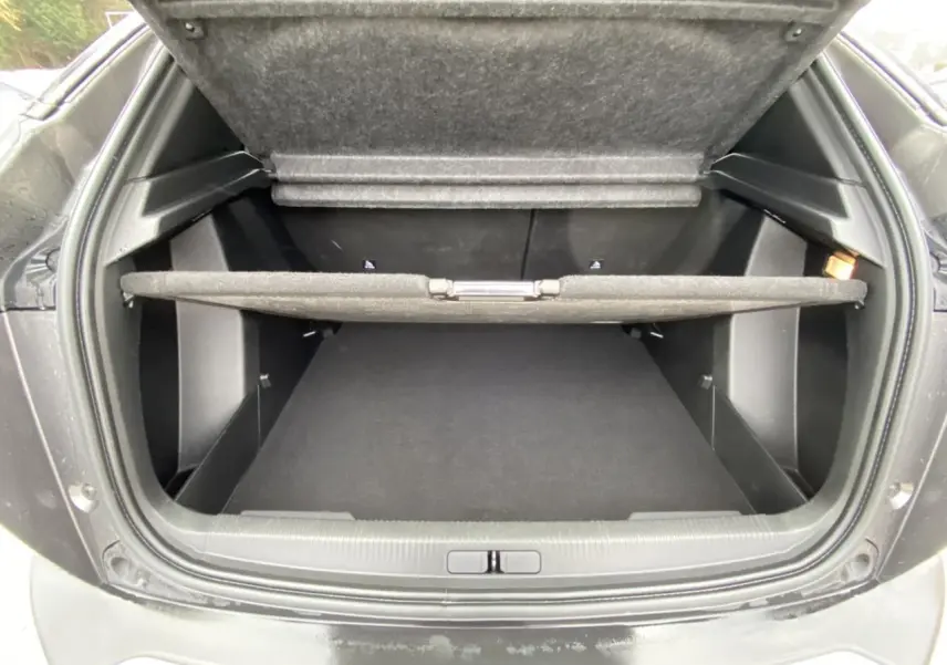 Coffre ouvert vu de l’arrière d’un Peugeot 2008 gris foncé, montrant l’espace de rangement et la tablette cache-bagages.