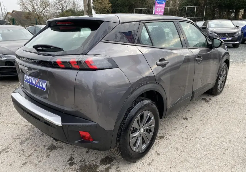 Peugeot 2008 gris foncé en 3/4 arrière droit, avec feux arrière LED 3 griffes et jantes alliage.