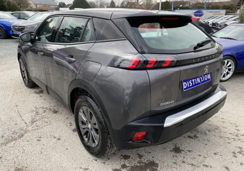 Vue 3/4 arrière droit d’un Peugeot 2008 gris foncé avec feux arrière LED en forme de griffes.
