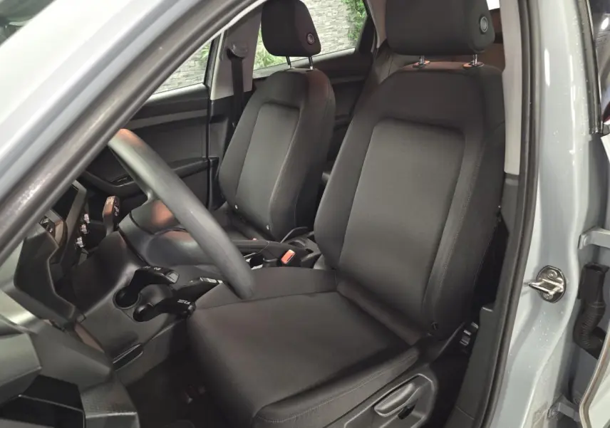Intérieur de l'Audi A1 Sportback gris, vue côté conducteur sur les sièges avant en tissu noir.