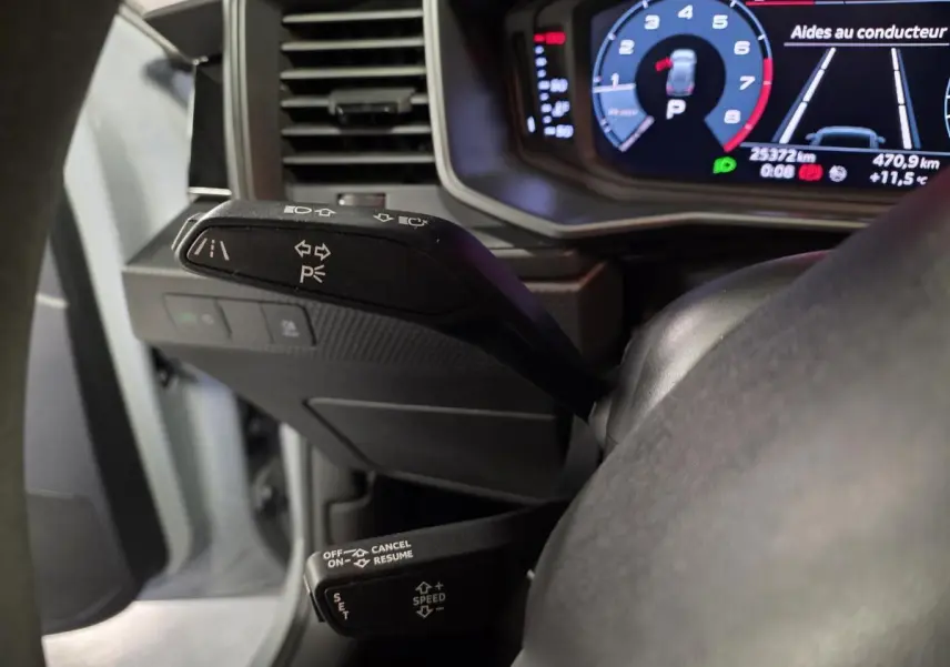 Gros plan sur les commandes au volant et le tableau de bord numérique d'une Audi A1 Sportback gris Manhattan.