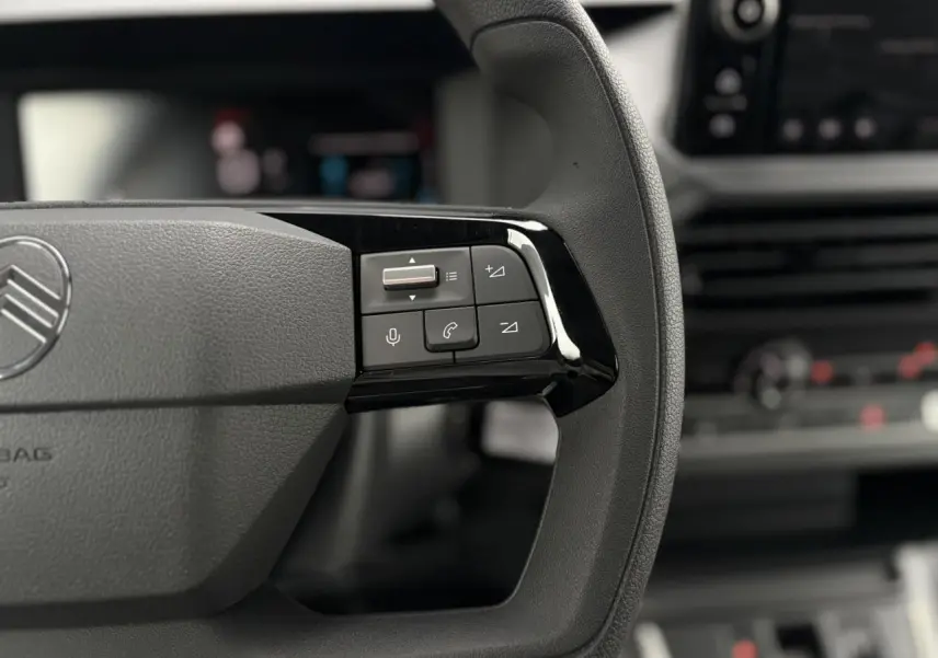 Gros plan sur la partie droite du volant noir du Citroën Jumpy 2025 avec commandes audio et téléphone intégrées.