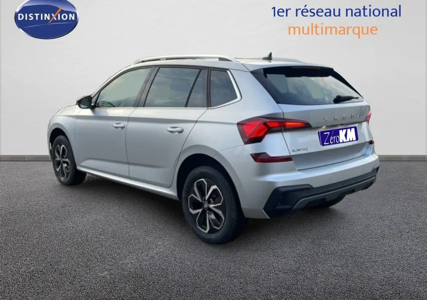 Vue 3/4 arrière côté droit d'un Skoda Kamiq gris argent métallisé avec jantes alliage et feux LED distinctifs.