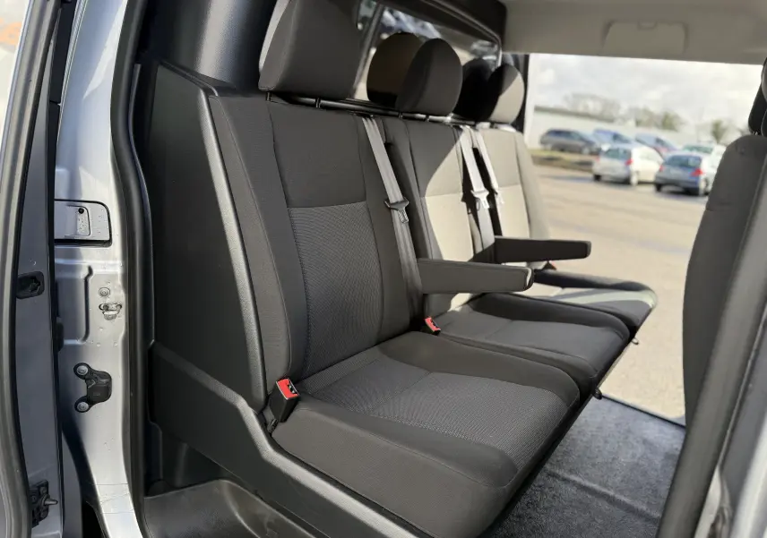 Vue intérieure côté droit des sièges arrière en tissu gris foncé du FIAT Scudo Cabine Approfondie gris, avec accoudoirs et ceintures visibles.