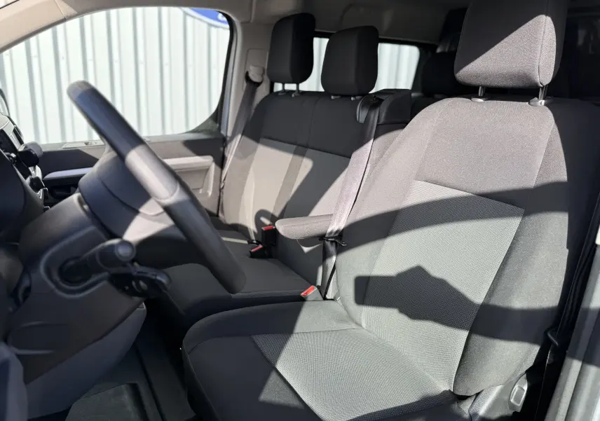 Vue intérieure côté conducteur du Fiat Scudo cabine approfondie 2022, sièges tissu gris et volant multifonction.