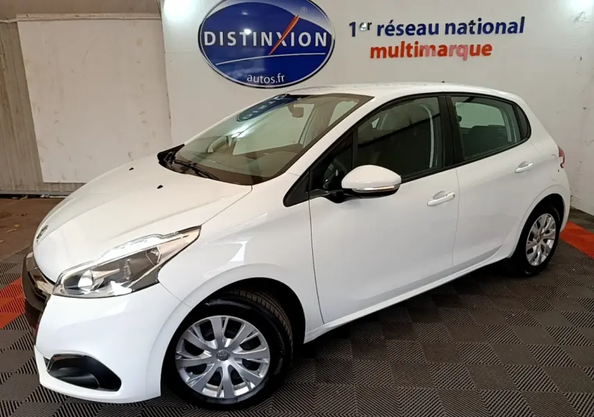 Peugeot 208 blanche vue 3/4 avant droit en intérieur avec jantes acier et rétroviseurs blancs.