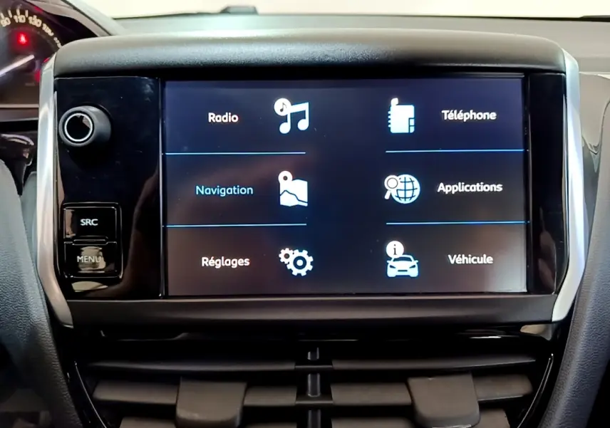 Écran tactile central de la Peugeot 208 Puretech 82 blanc, affichant les options radio, navigation et téléphone.