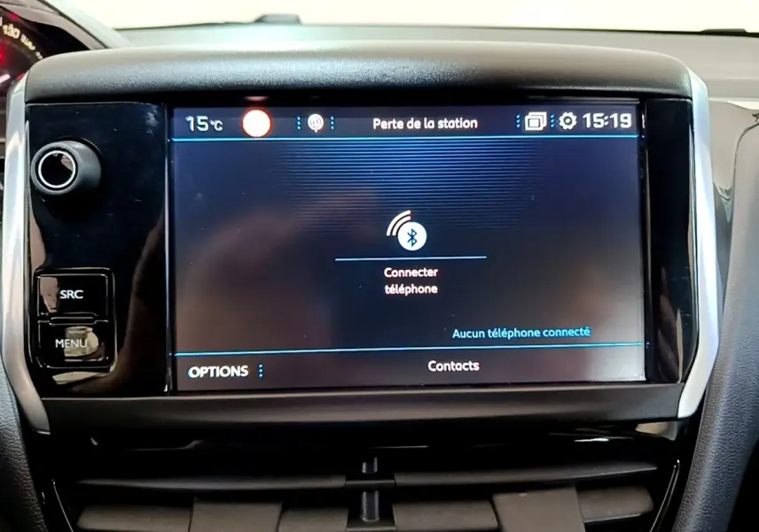 Écran tactile central de la Peugeot 208 Puretech 82 blanc, affichant la connexion Bluetooth téléphone.