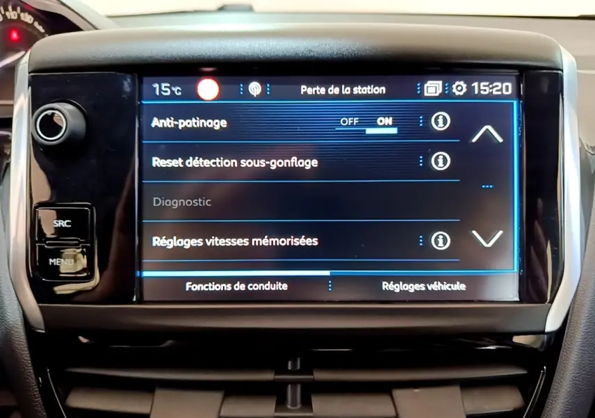 Écran tactile central de la Peugeot 208 blanche, affichant les réglages d'anti-patinage et sous-gonflage, vue frontale rapprochée.