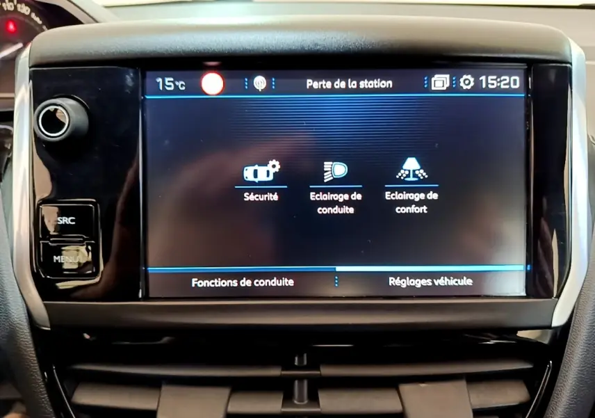 Écran tactile central de la Peugeot 208 Puretech 82 blanc, affichant les réglages de conduite et sécurité.