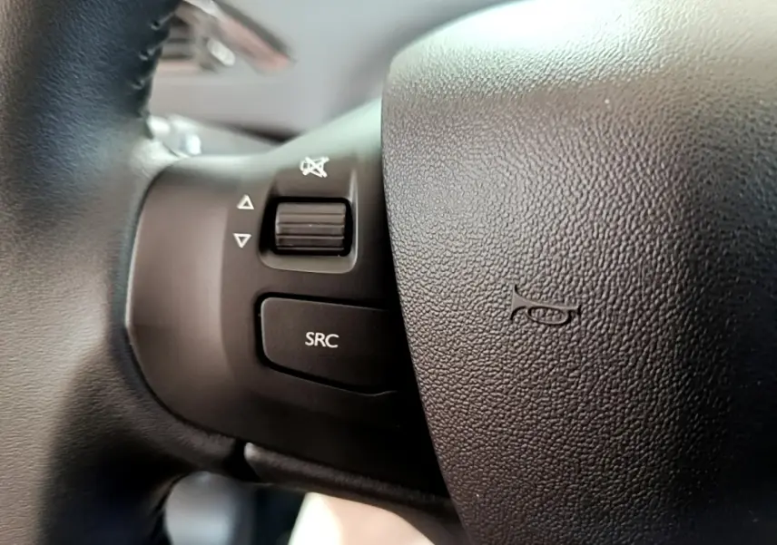 Gros plan sur les commandes audio au volant noir de la Peugeot 208 Puretech 82 S&S Active Business 2018.